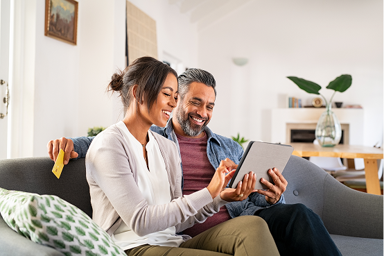 Couple sitting on a couch reviewing financial paperwork